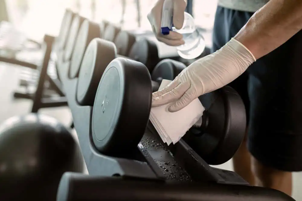 close-up-of-athletic-man-cleaning-dumbbells-with-d-2023-11-27-05-20-06-utc (1)